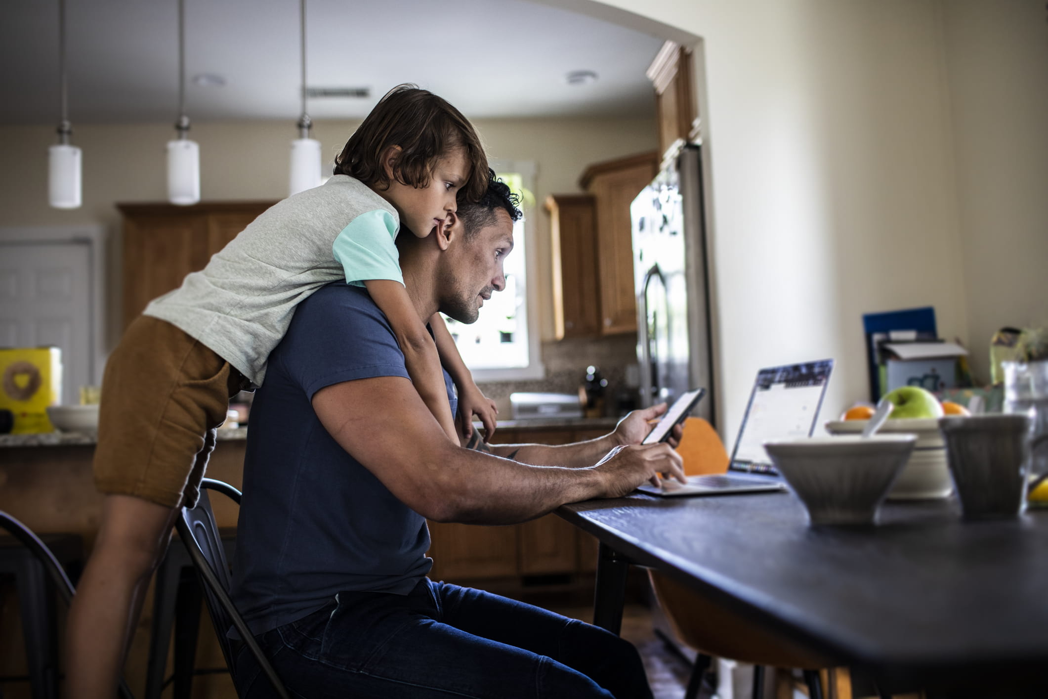 father-using-laptop-while-his-son-plays-personal-values-examples