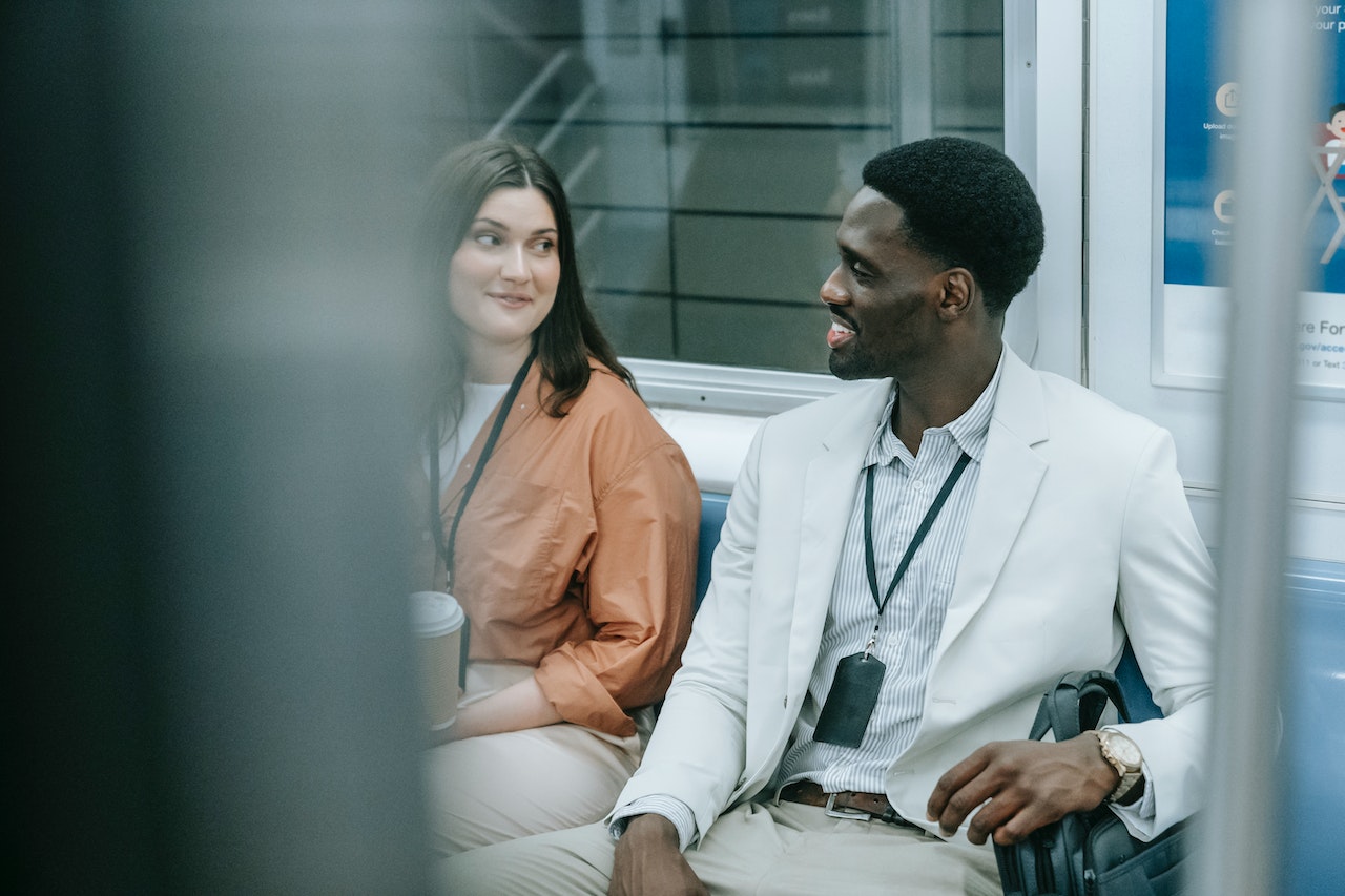 man-and-woman-sitting-on-metro-talking-confidently-communication-coach