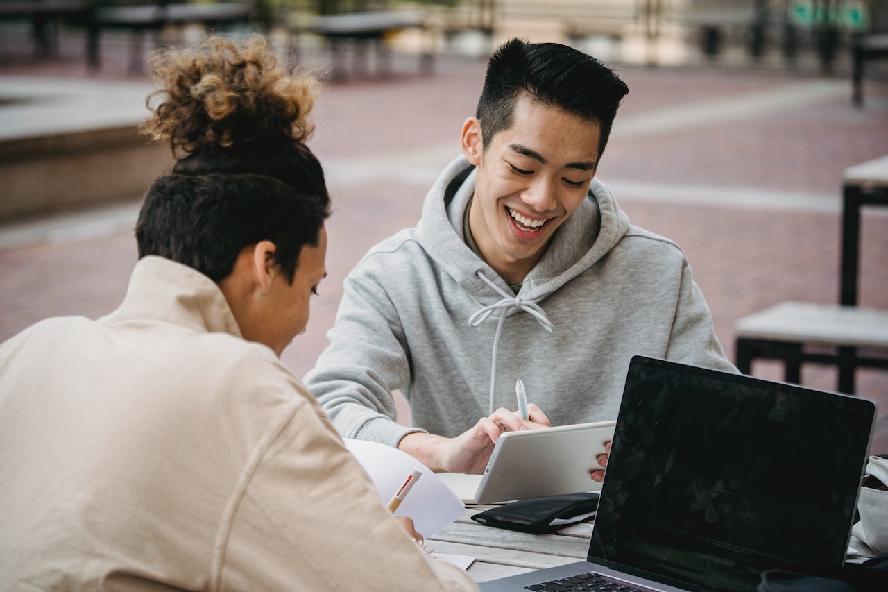 man-talking-to-person-while-outdoors-using-laptops-professional-coaching