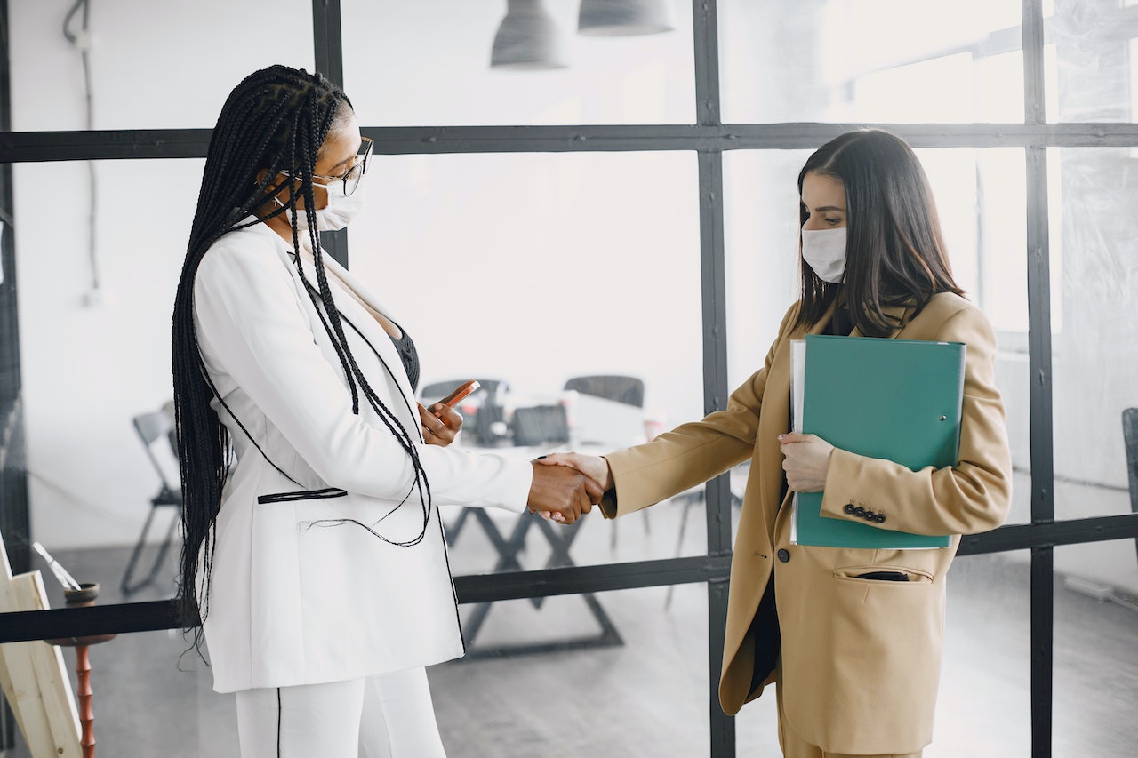 Two-coworkers-shaking-hands-after-meeting-negotiation-strategies