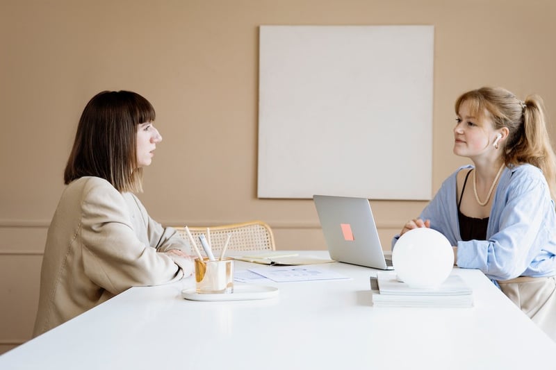 two-woman-sitting-in-office-talking