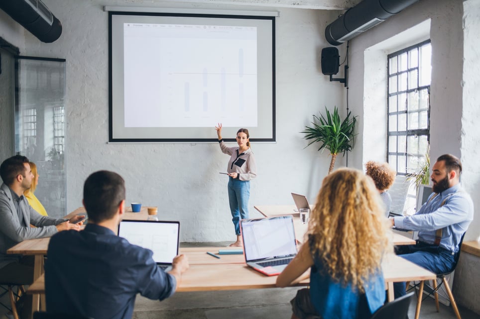 Woman-presenting-in-front-of-a-group-of-business-people-how-to-give-a-good-presentation